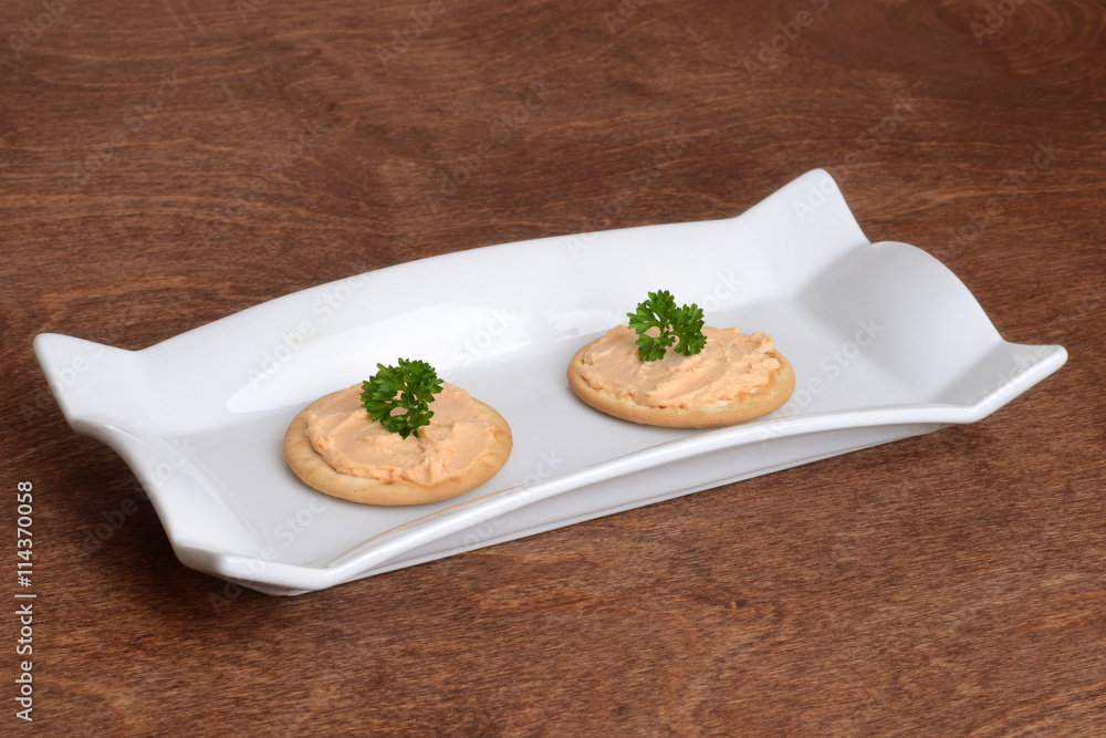 salmon pate crackers with parsley on a plate