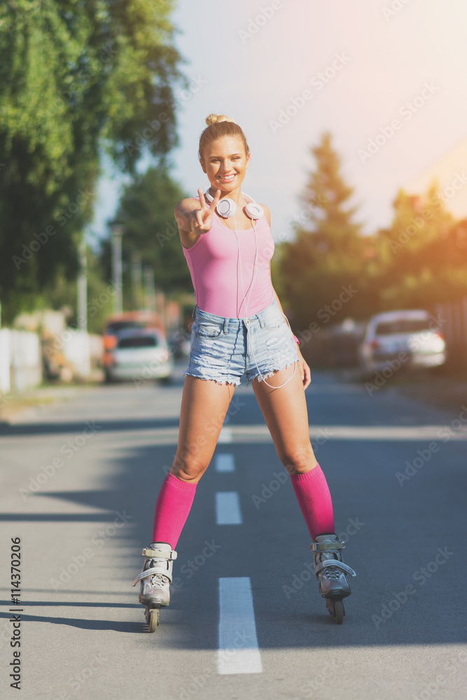 Cheerful teenage girl rolle rskating on the street Cheerful teenage girl rolle rskating on the street