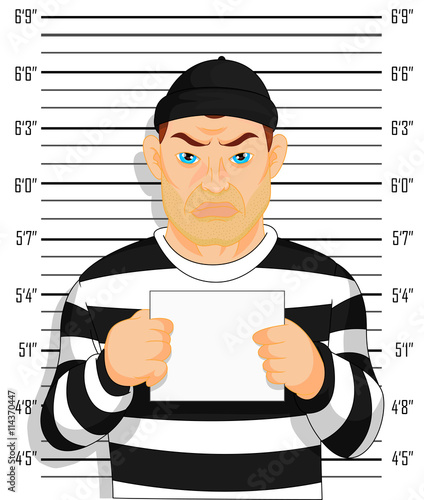 Criminal photo Caught criminal stands beside wall with number in hand