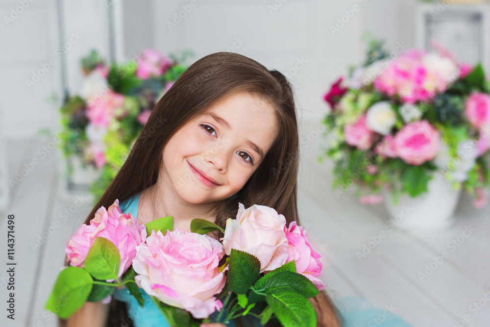 Portrait of smiling pretty little girl with a the flowers in a studio Portrait of smiling pretty little girl with a the flowers in a studio