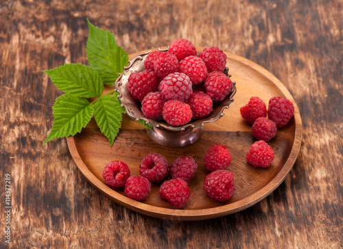 Fresh raspberry in a wooden plate