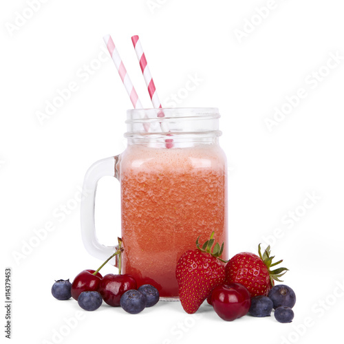 Healthy drinks and smoothies - a red blended fruit smoothie in a vintage glass jar with stripe straws, and decorative strawberries, blueberries and cherries isolated on a white background