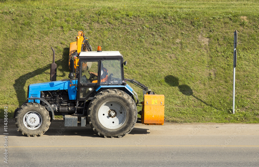 Obraz premium Tractor mowing green grass
