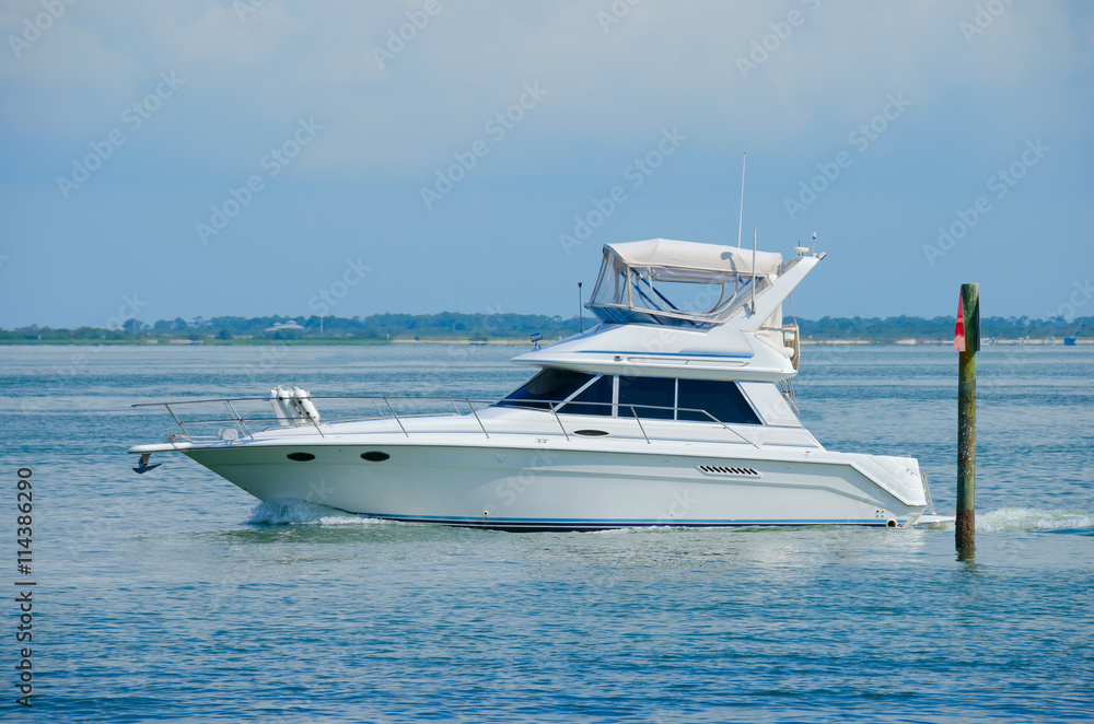 Fototapeta premium Large boat yacht cruising by channel marker