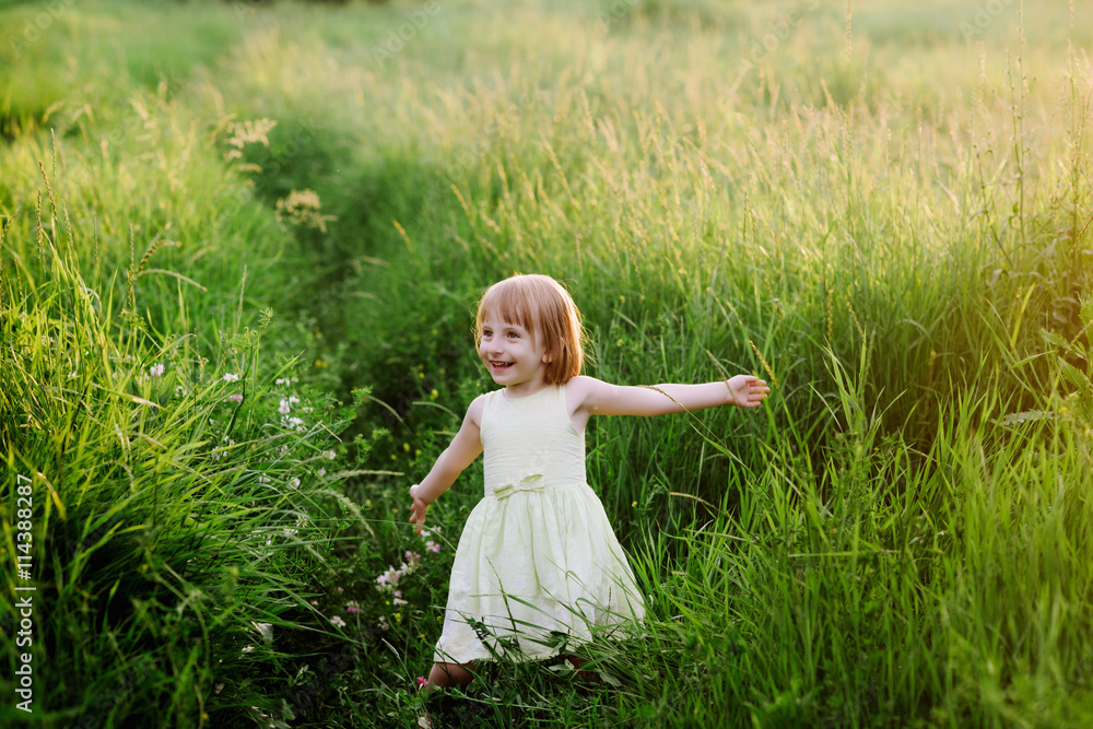 Outdoor portrait of a cute little girl playing in the grass, childhood, happiness, nature, relaxation Outdoor portrait of a cute little girl playing in the grass, childhood, happiness, nature, relaxation