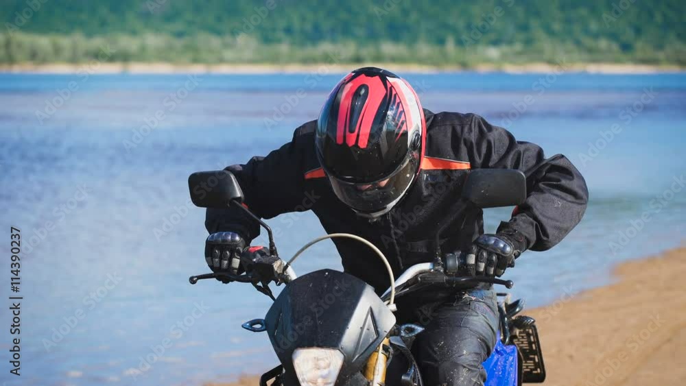 Young biker on the river bank, is preparing to start Young biker on the river bank, is preparing to start