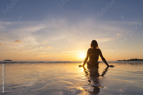 Girl on vacation relaxing on the beach  looking at sunset