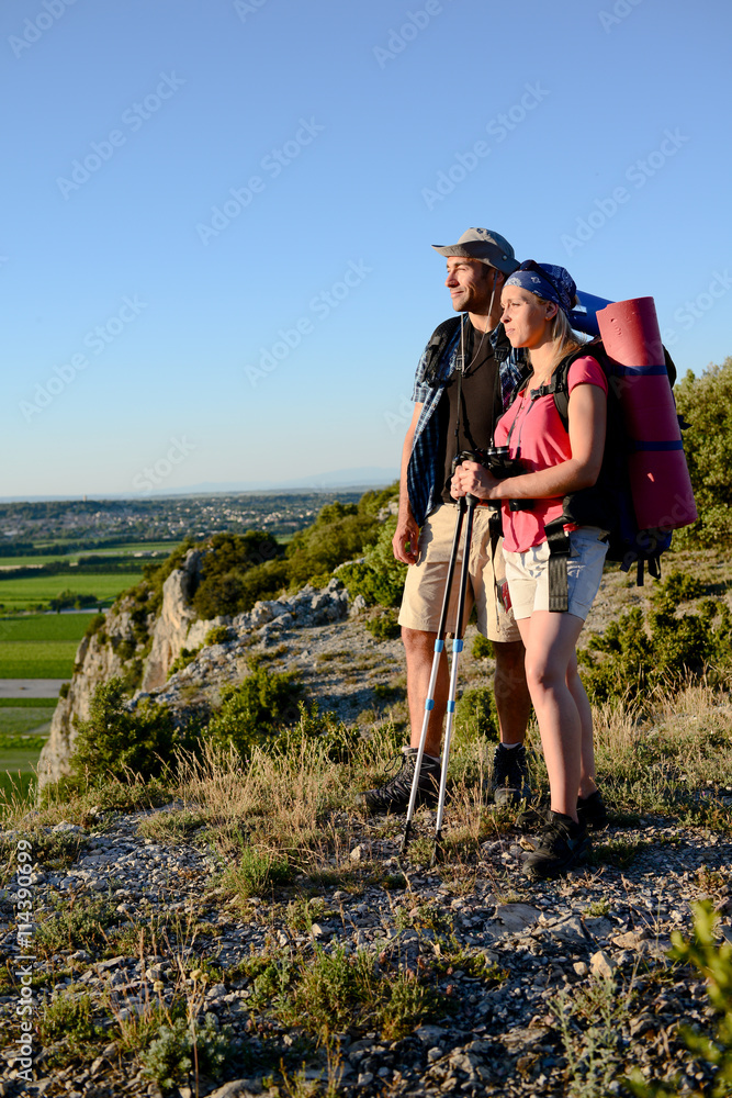 young couple hiking on an adventure trek and looking at beautiful landscape