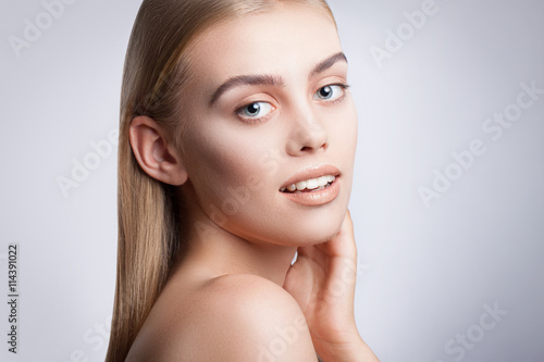 Portrait of a young beautiful blue-eyed girl. Beautiful make-up, perfectly smooth hair, blue eyes, open arms, perfect skin.
