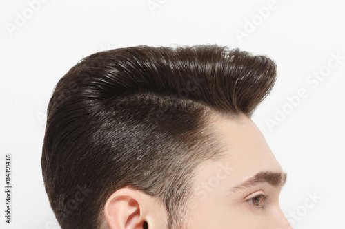 Top view profile of young handsome man's hair over white background. Model male with modern hairstyle posing for fashion magazine in studio.