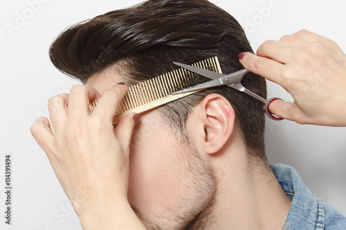 Closeup portrait of handsome young man having haircut in studio Fotobehang