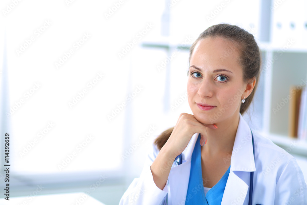 Portrait of young female doctor sitting at desk in hospital Portrait of young female doctor sitting at desk in hospital