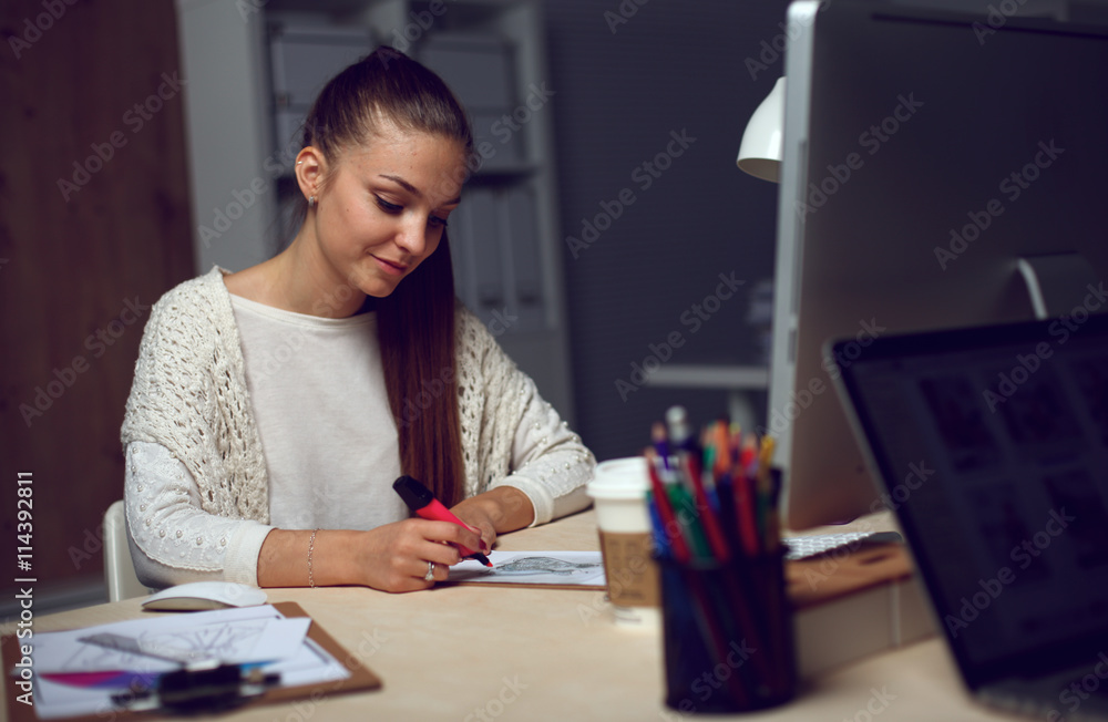 Young woman working in office, sitting at desk Young woman working in office, sitting at desk