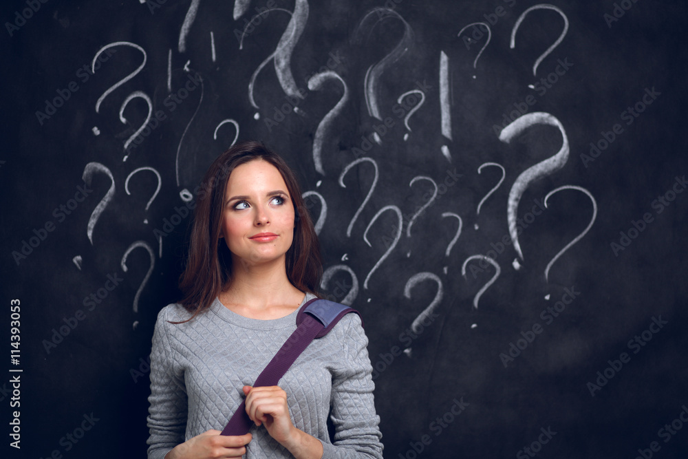Young girl with question mark on a gray background Young girl with question mark on a gray background