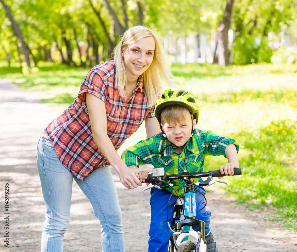 happy mother with her son having fun, riding a bicycle happy mother with her son having fun, riding a bicycle