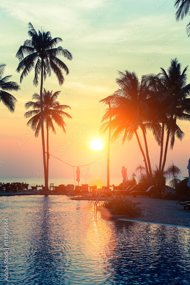 Silhouettes of palm trees on the sea beach during a tropical sunset. - obrazy, fototapety, plakaty 