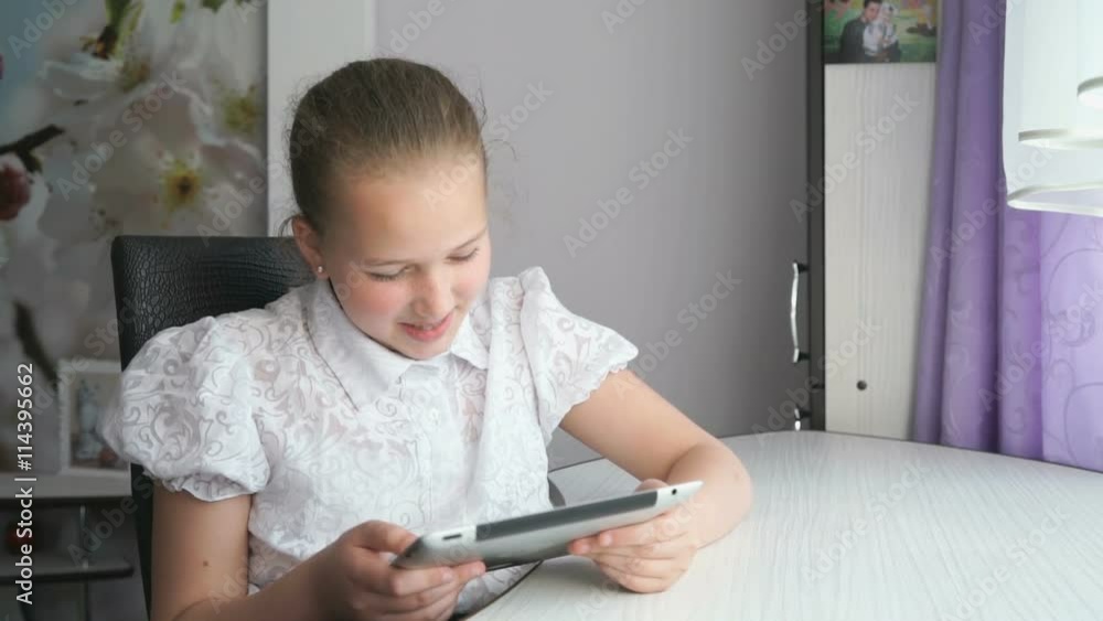 Cute little girl uses a digital tablet computer Cute little girl uses a digital tablet computer