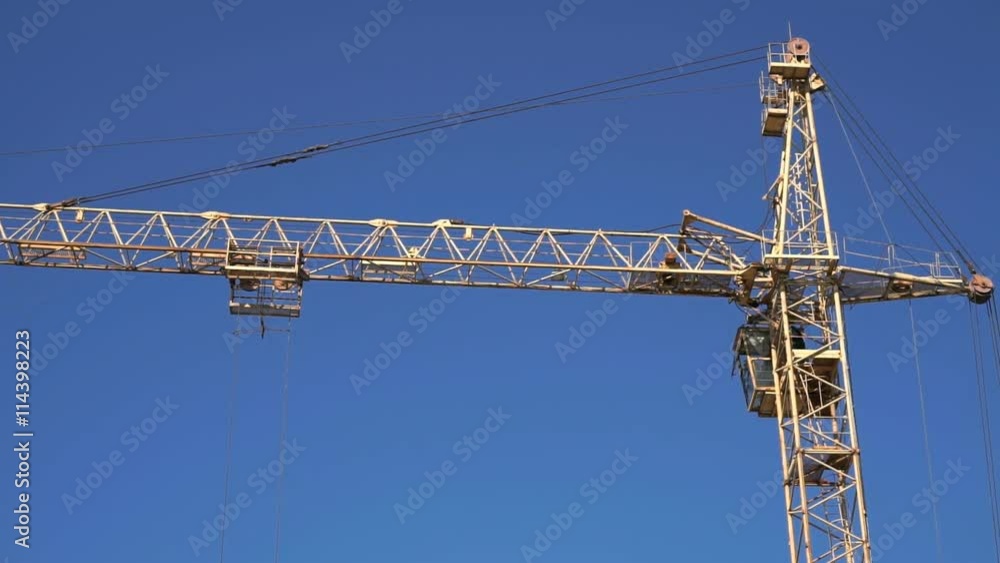 One construction crane working in the blue sky One construction crane working in the blue sky