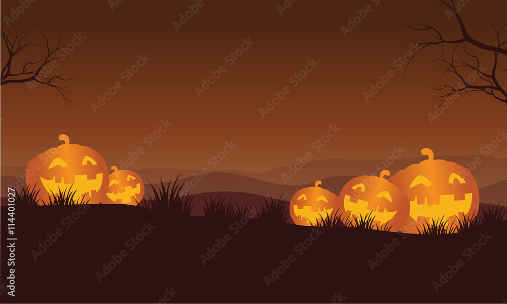 Silhouette of Halloween orange pumpkins in hills