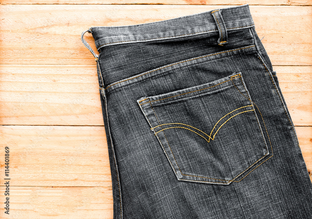 the black jeans on wooden background the black jeans on wooden background