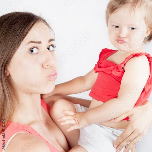 Close-up funny baby girl and her mother on white background