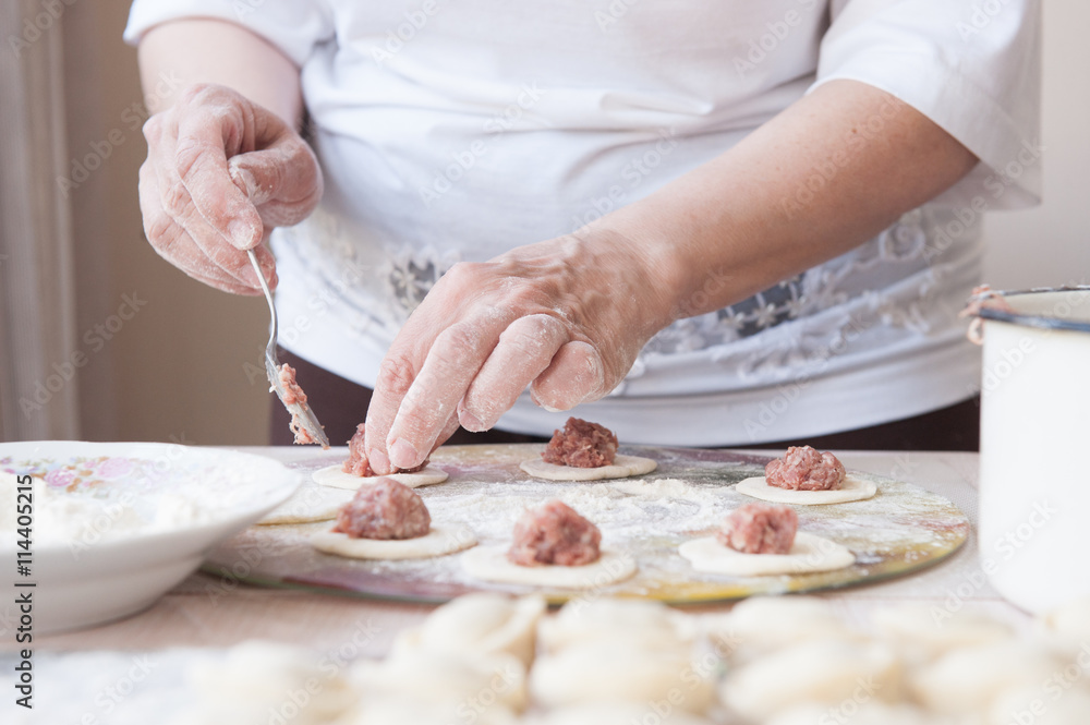 woman cooks dumplings in the kitchen