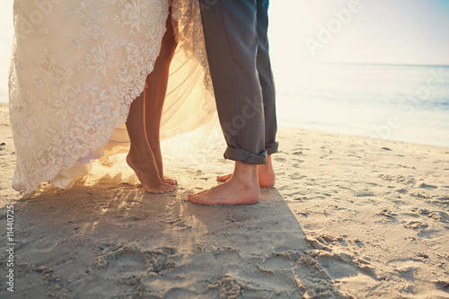 Fototapeta Naklejka Na Ścianę i Meble -  Bride and groom are standing at the beach