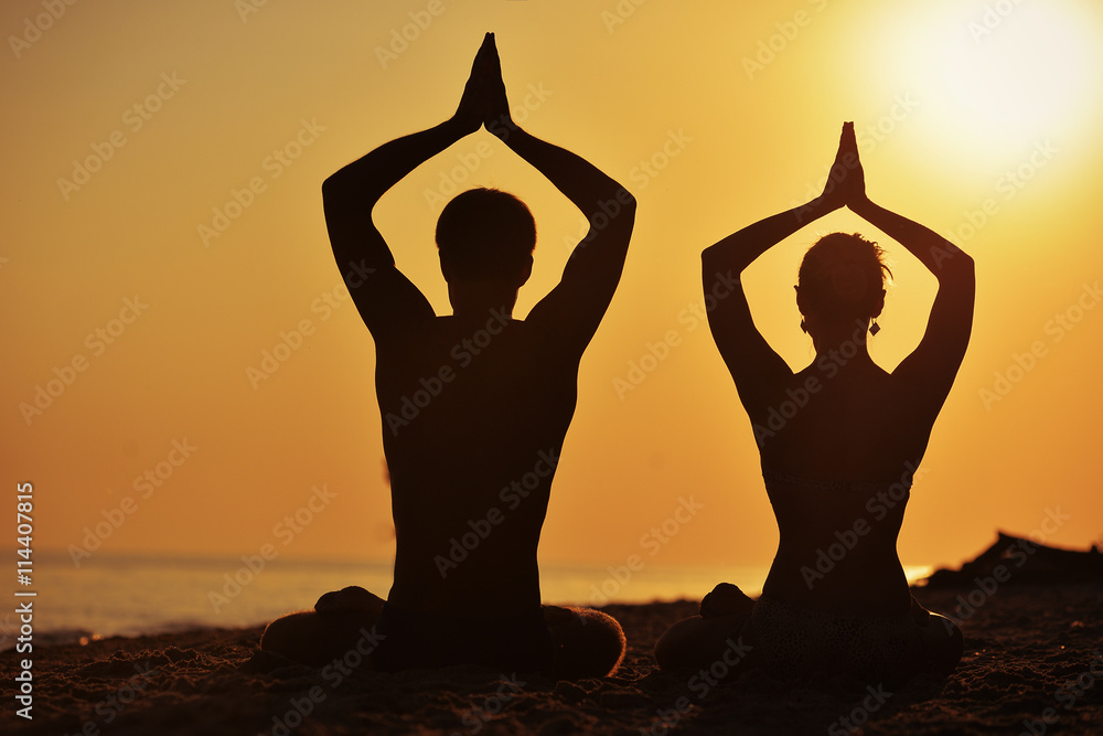 man and woman in a lotus position silhouette