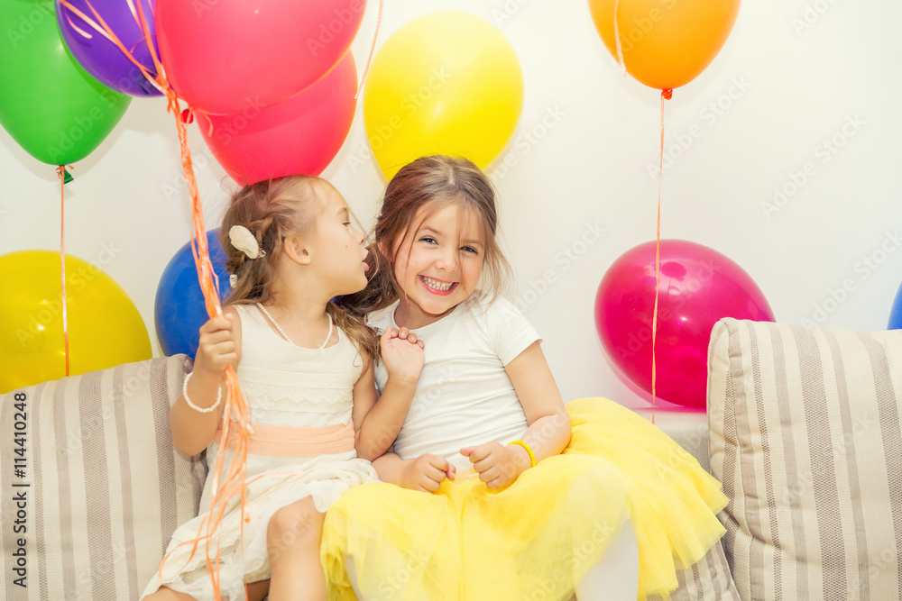 Two little girls talking at a birthday party - obrazy, fototapety, plakaty 