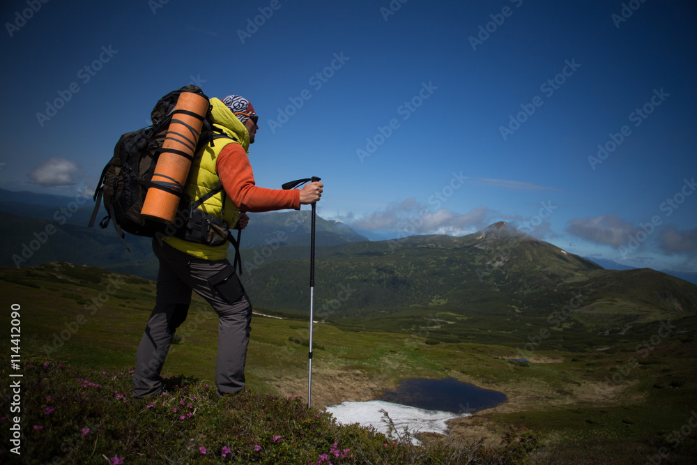 Summer hiking in the mountains with a backpack and tent.