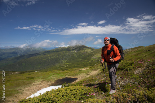 Summer hiking in the mountains with a backpack and tent.