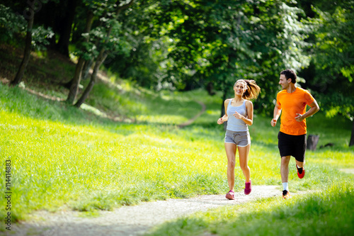 Fototapeta Naklejka Na Ścianę i Meble -  Athletic couple jogging in nature
