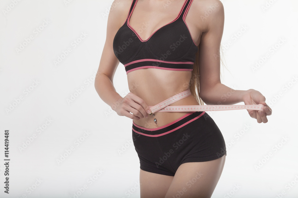 Woman measuring her slim body on white background. Health concept. Woman measuring her slim body on white background. Health concept.