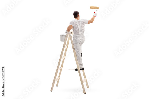 Male decorator painting with a roller photo
