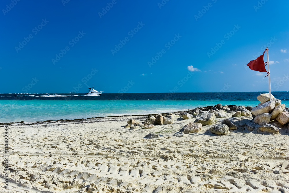 Fototapeta premium White sandy beaches and beach flag and boat at Cancun