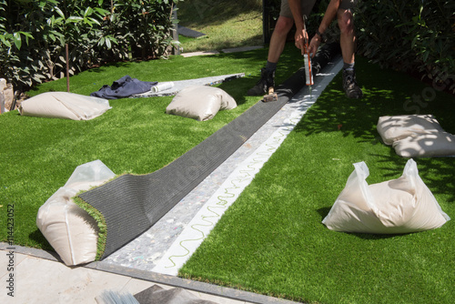 professional gardener is glueing artificial turf to fit
