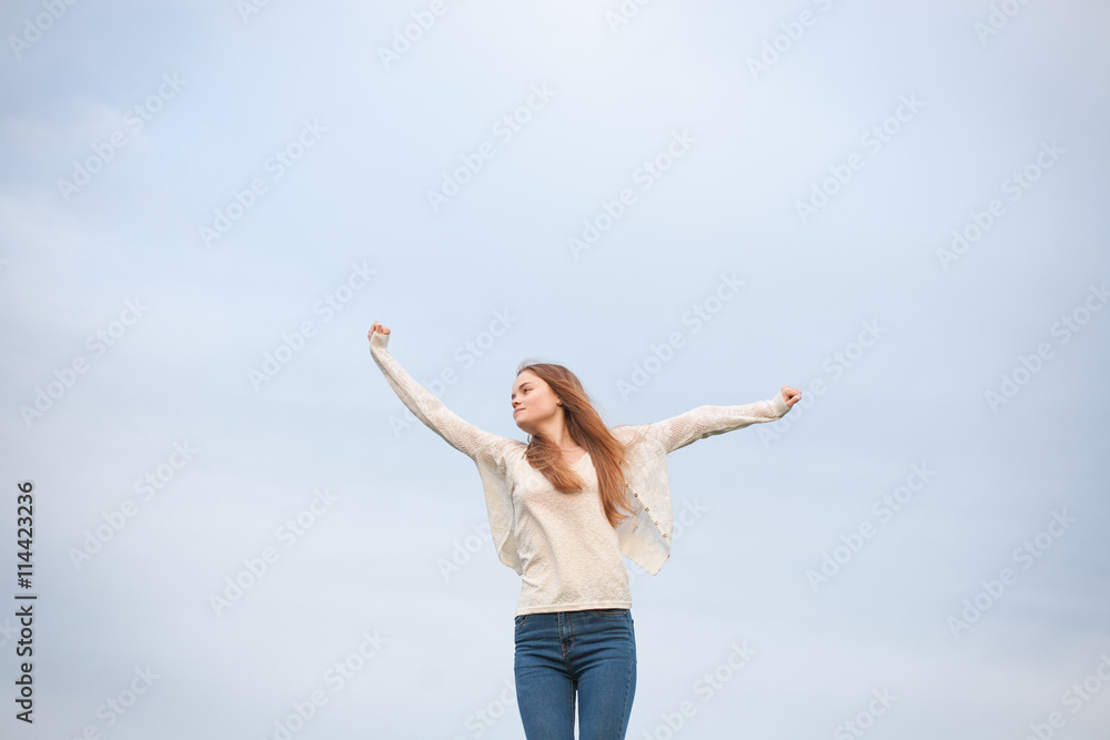 woman with open arms in the sky background at the morning.