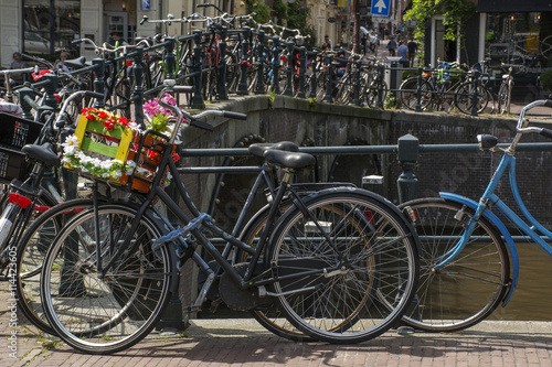 Bike with flower basket on the street near the canal in Amsterdam in Europe © Anastasia Pestova