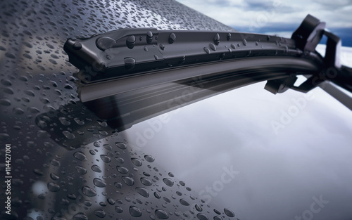 Car windshield with rain drops and frameless wiper blade closeup. 3d render photo