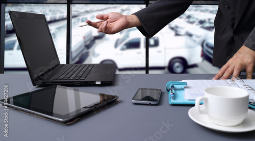 bussiness man working in office with  New Cars in Stock. Car Dealership Cars For Sale background photo