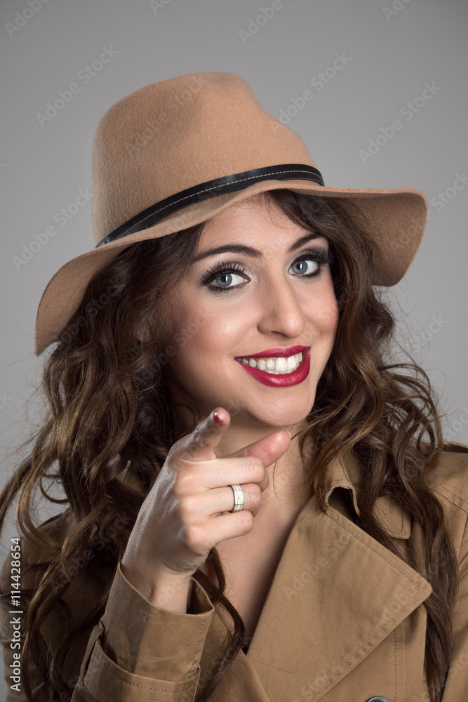 Pretty young beauty pointing finger at camera choosing you. Portrait over gray studio background Pretty young beauty pointing finger at camera choosing you. Portrait over gray studio background
