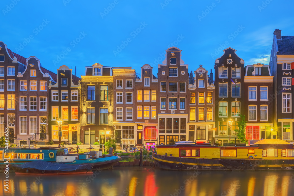 Amstel river, canals and night view of beautiful Amsterdam city. Netherlands.