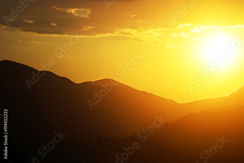 Bright sun over the mountain at sunset