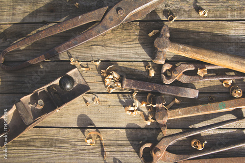 Rusty set of hand tools on a wooden background. Vintage photo