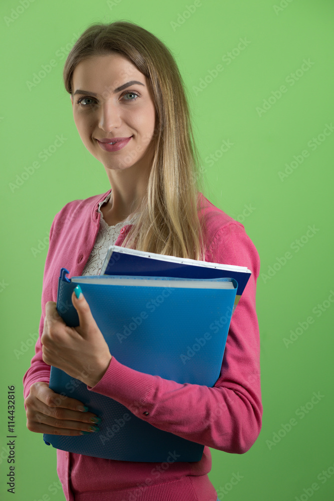 Young cute woman standing holding folder, green background Young cute woman standing holding folder, green background