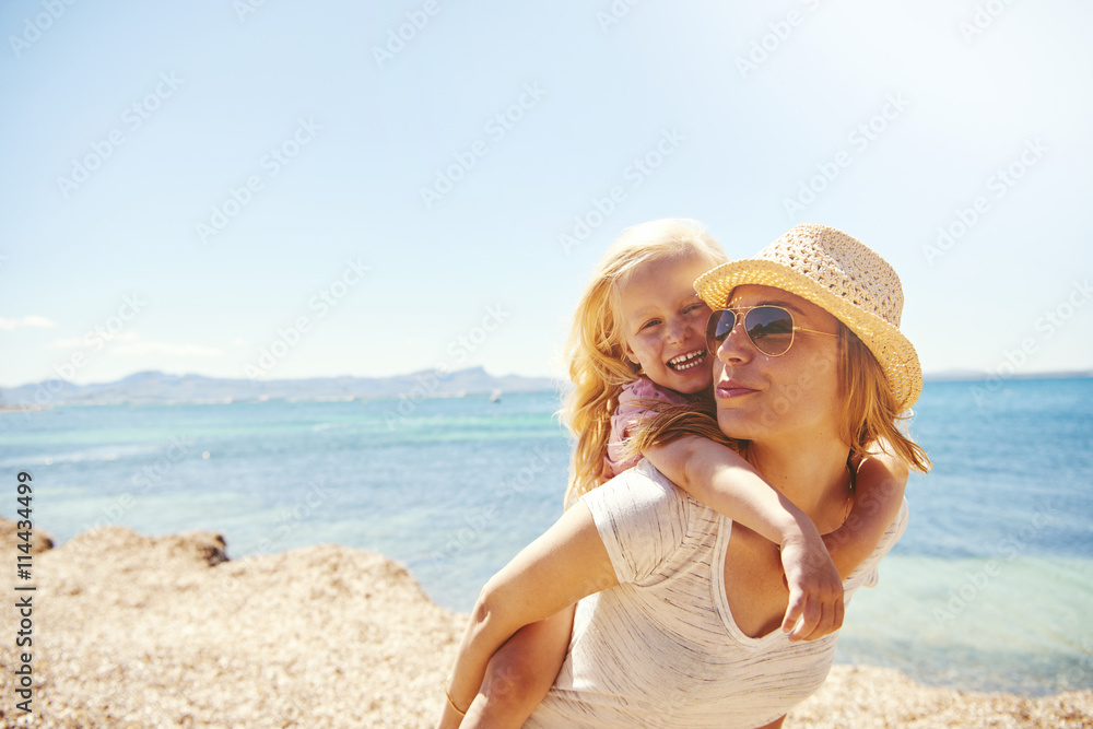 Laughing little girl with her mother at the beach Laughing little girl with her mother at the beach