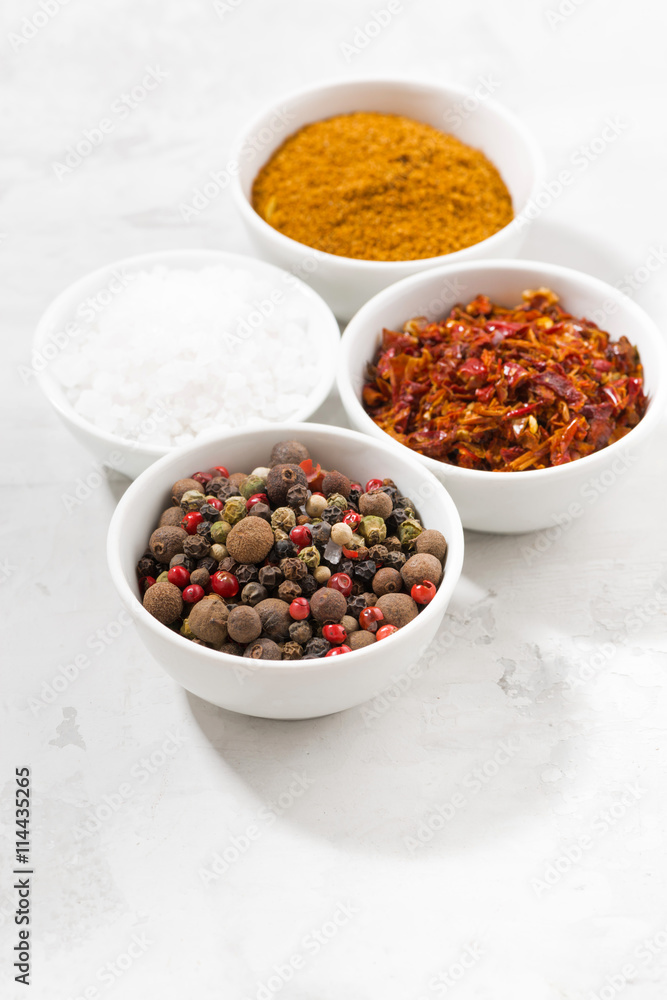 assortment of pepper, salt and spices in bowls, vertical assortment of pepper, salt and spices in bowls, vertical