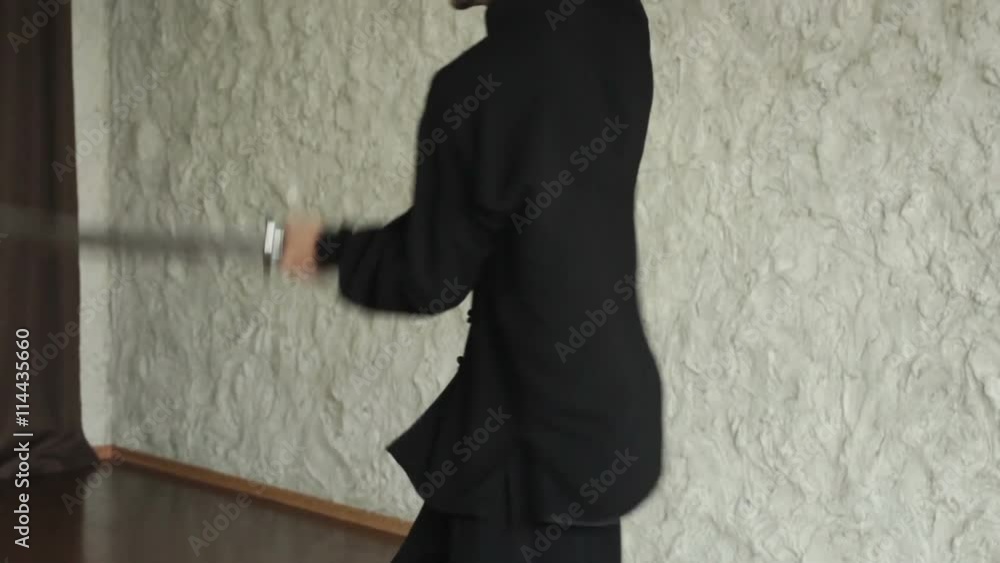 Man practicing elements of tai chi. The man rotating steel swords around a body Man practicing elements of tai chi. The man rotating steel swords around a body