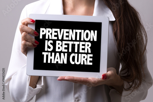 Female doctor holding a tablet with the text: Prevention is Better Than Cure photo