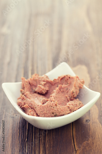 pork pate in bowl on brown wooden background